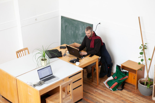 Image qui montre comment est notre coworking. On y voit un homme assis à une table devant son ordinateur.